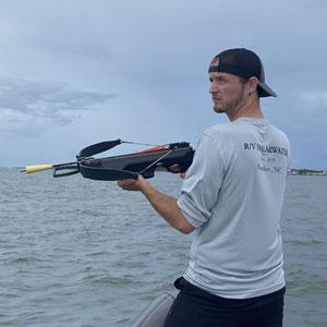 Greg Merrill, Ph.D. candidate in ecology, looks for dolphins to biopsy blubber from using a specialized crossbow bolt off the North Carolina coast. NMFS Permit #22156