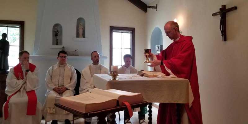 Photo: Adam Booth (right) performs the Eucharist at a symposium in Berkeley, California, in August 2018.