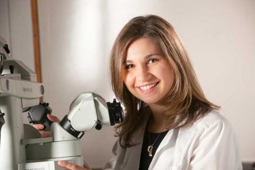 Lucinda Camras posing with a microscope.