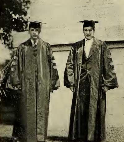 Dean Warren Rumbold and Frederick John Holl stand side-by-side in their cap and gowns.