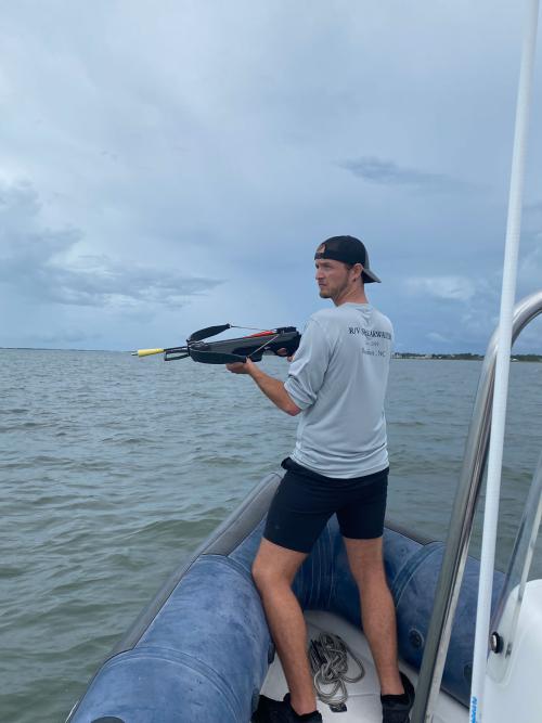 Greg Merrill, PhD candidate in Ecology, looks for dolphins to biopsy blubber from using a specialized crossbow bolt off the North Carolina coast. NMFS Permit #22156