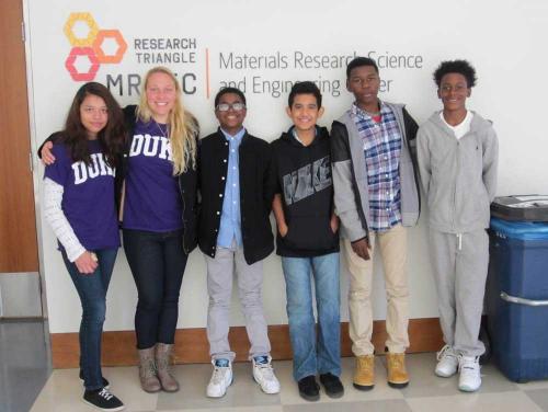 A group stands in front of a sign for the Research Triangle Materials Research Science and Engineering Center (RT-MRSEC).