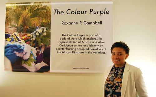 Roxanne Campbell smiles as she stands next to her final project, "The Colour Purple."
