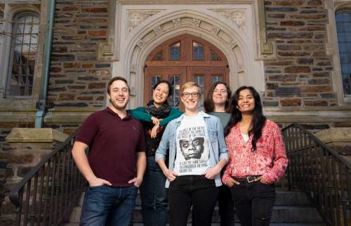 Five members of the Biology Department's diversity committee pose in front of an on-campus building.