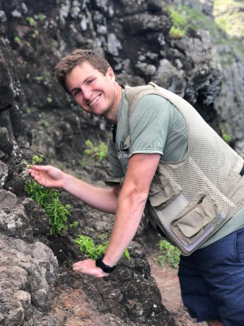 Alex Loomis poses with the plants he's working to save